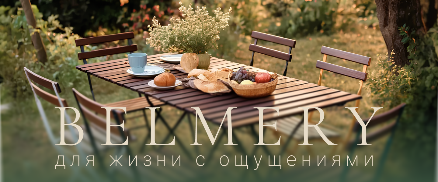 Мебель Belmery на террасе среди зелени — стол с хлебом, фруктами и цветами, атмосфера уюта под открытым небом.
